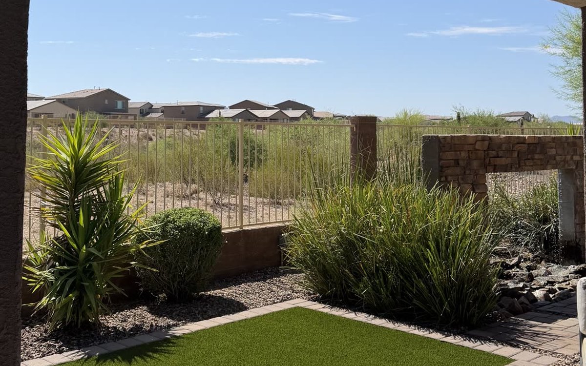Completed Tucson desert backyard transformation by Ultra Men with artificial turf, paver border, decorative rock and desert plants