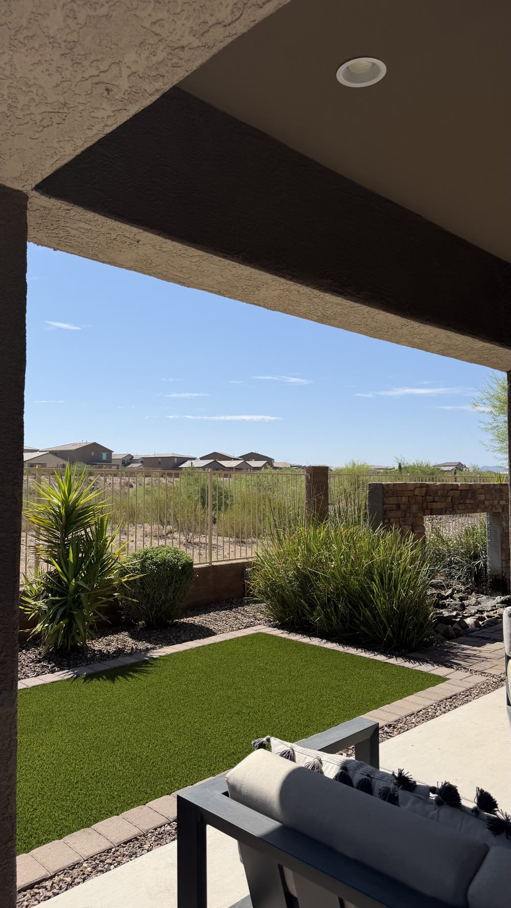 Finished Tucson backyard with artificial turf, paver border, desert plants and water feature