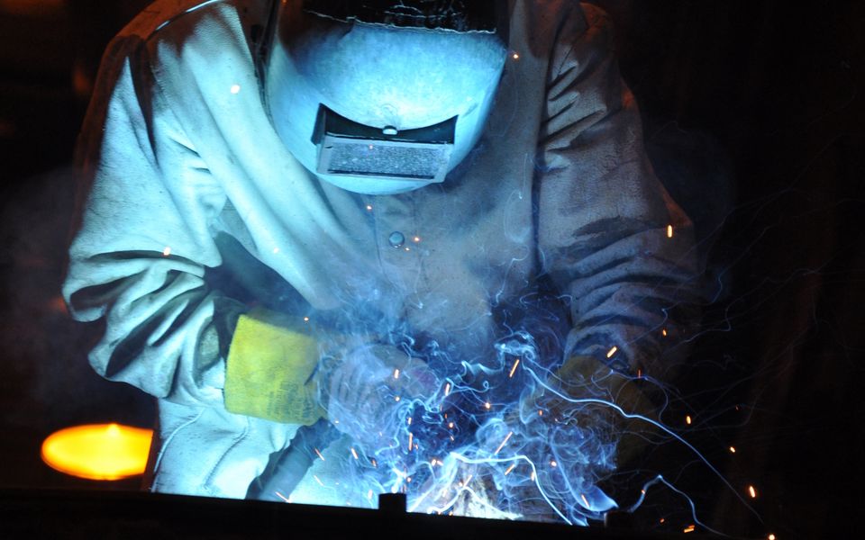 Custom welding with a bright blue arc and sparks